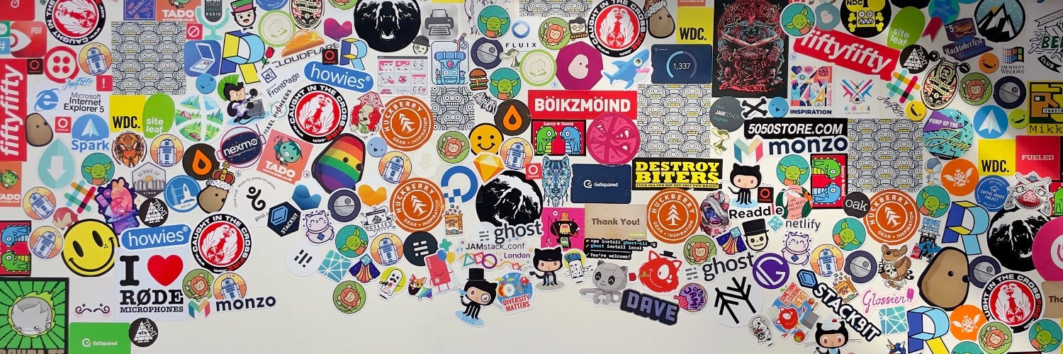 A white desk covered in tech-focussed stickers